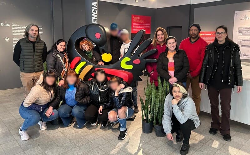 Jóvenes y educadores posando frente a una gran escultura